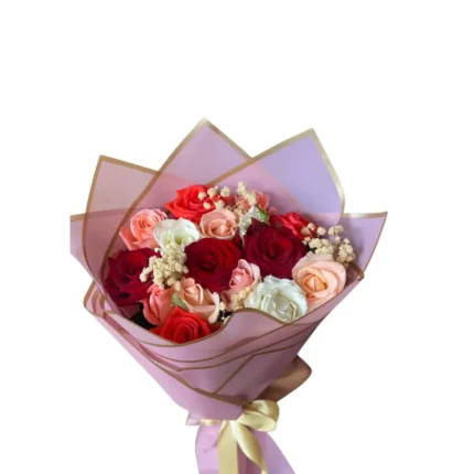 Bouquet Mélodie des Cœurs composé de roses rouges, roses et blanches, emballage rose élégant.