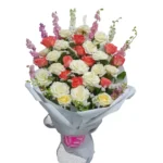 Bouquet Félicité Florale composé de roses blanches et corail avec fleurs mauves, emballage blanc élégant.